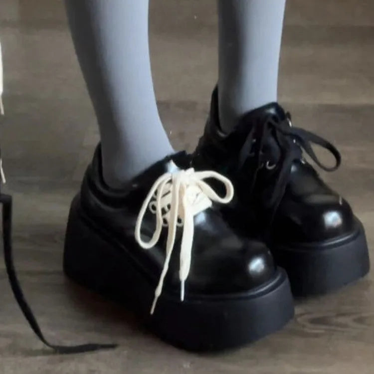 Matte black women's lace-up leather shoes with a thick sole and a chunky heel.