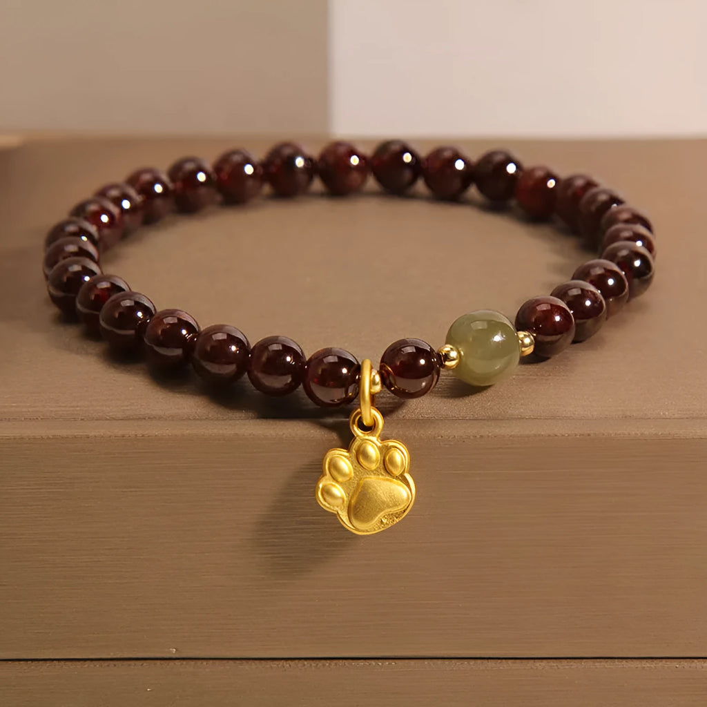 Women's original design Cat's Paw Garnet crystal bracelet on a plain background.