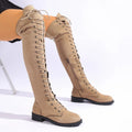 Black lace-up over the knee boots with a round toe and flat rubber sole on a neutral background.