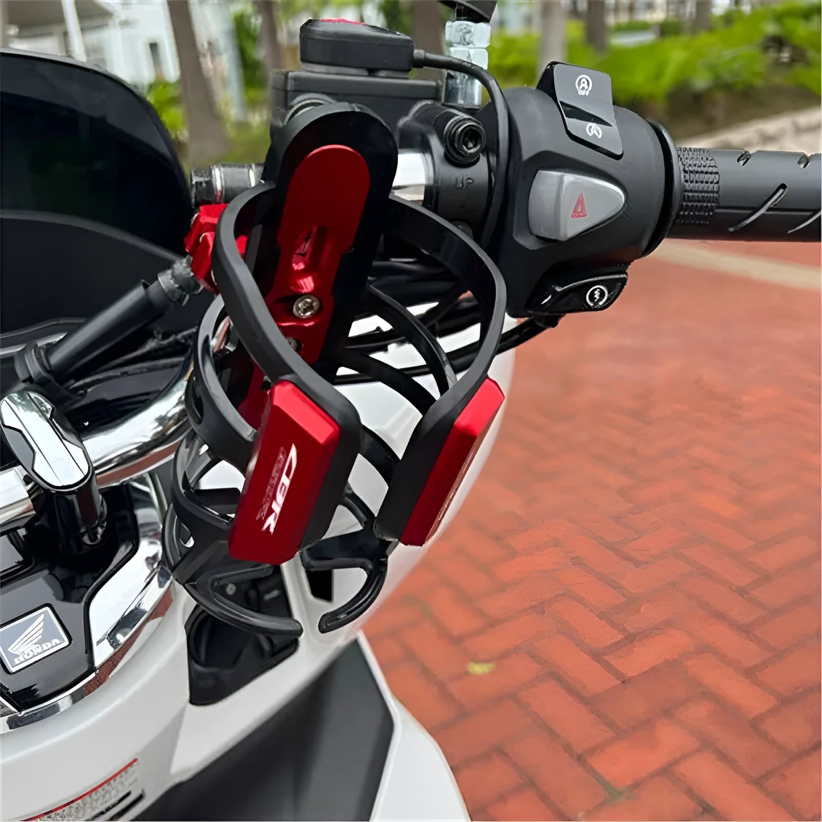 Modified black water bottle cage mounted on a Honda X-ADV scooter bumper.