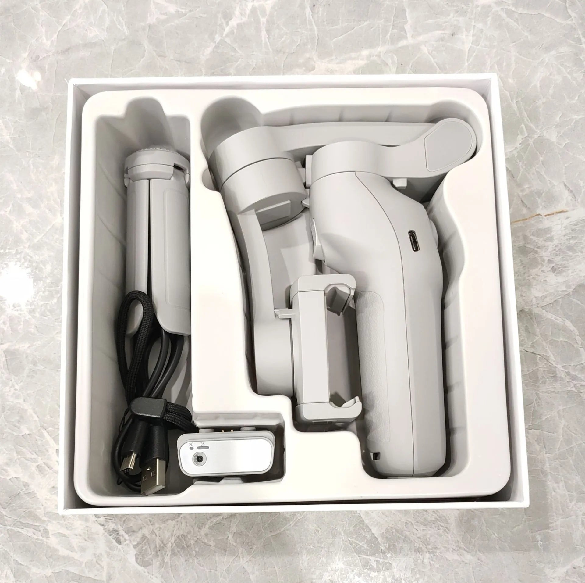 New foldable handheld stabiliser in silver grey for mobile phone with Type-C cable and manual