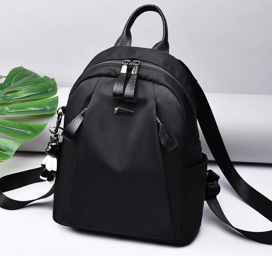 Medium square-shaped Oxford cloth rucksack in grey with double straps and a soft handle.