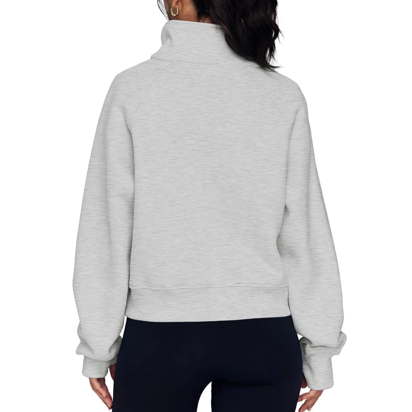 A woman wearing a loose-fitting apricot-coloured fleece-lined sweater with a lapel neckline and raglan sleeves.