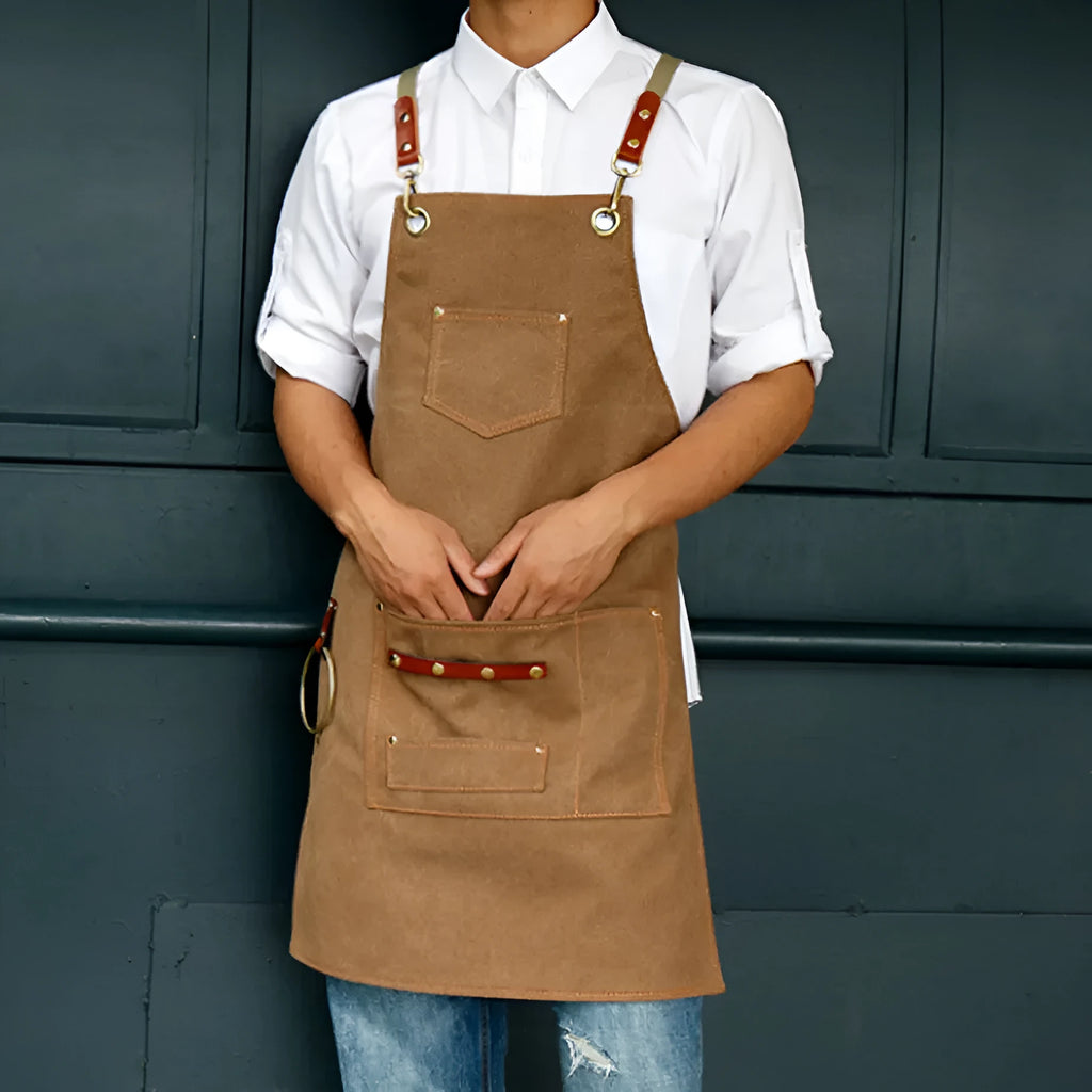 Canvas apron with cross-strap design in camel colour for café work and baking