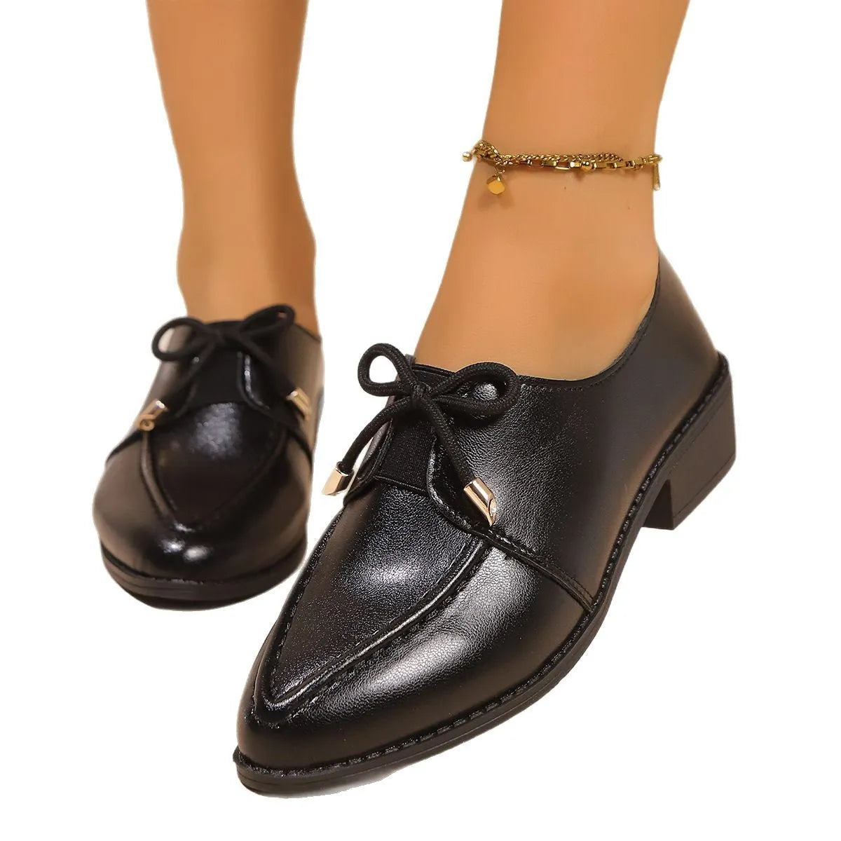 Women's simple leather-look flat shoes with a decorative bow, shown in slip-on style with a rubber sole.