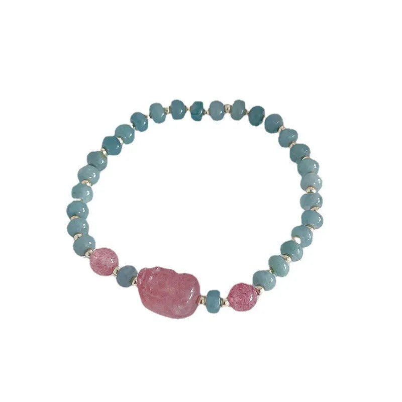 Women's jade bracelet with gourd shape, peace buckle charm, and strawberry quartz details in natural blue colours