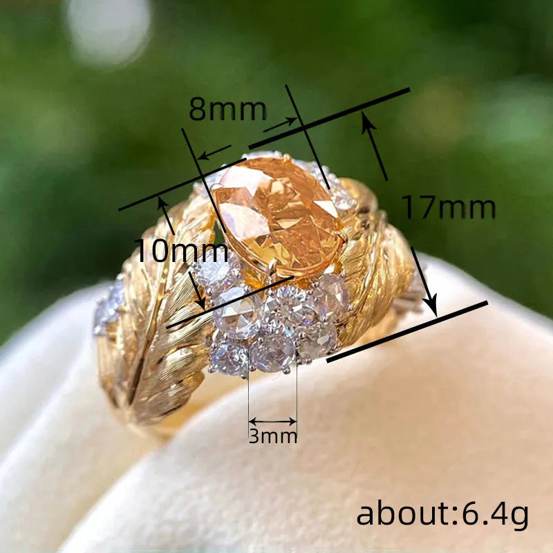 Gold-coloured copper ring with an embossed geometric feather pattern and inlaid yellow zircon stones.