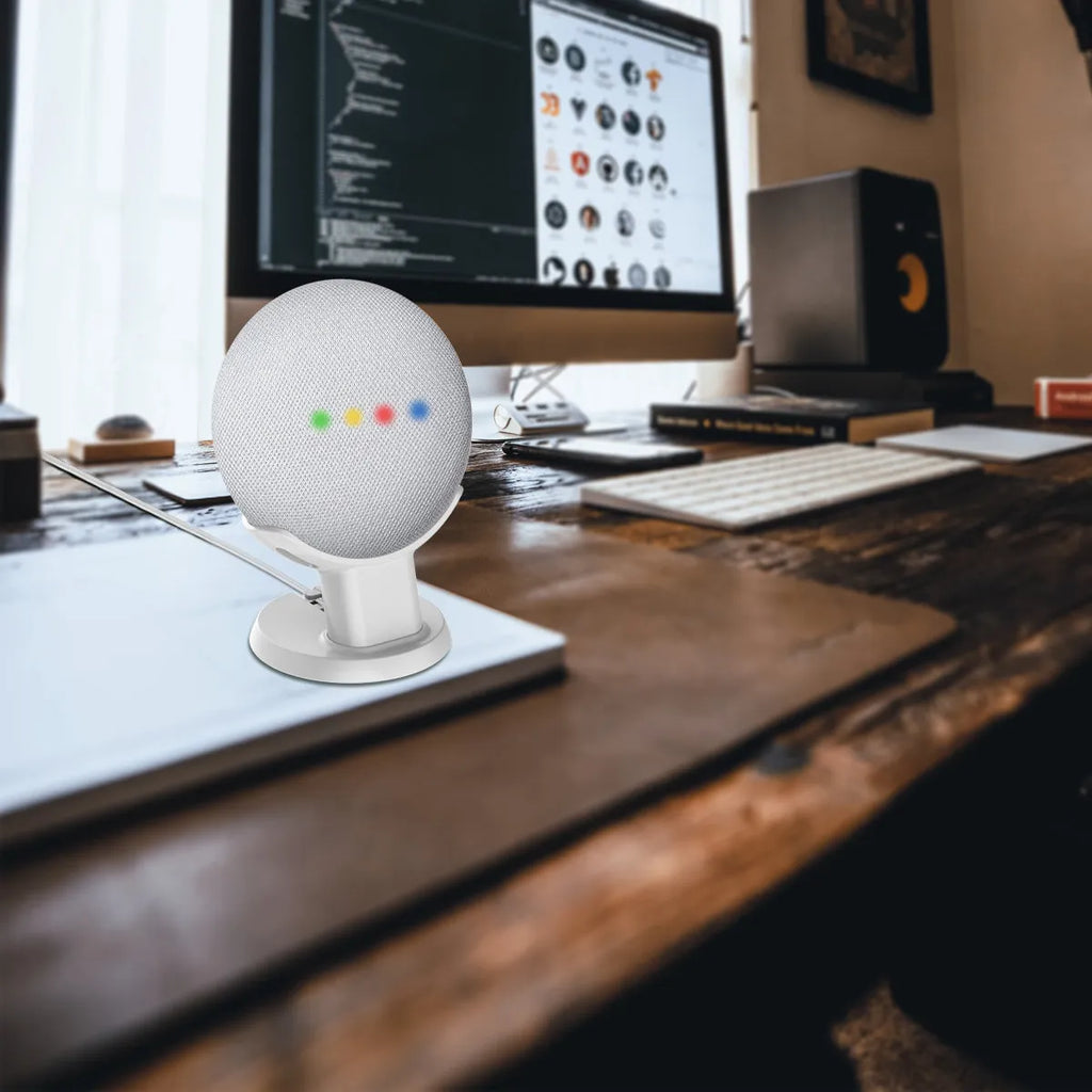 Black PlusAcc plastic stand holding a Google Home Mini speaker on a table.