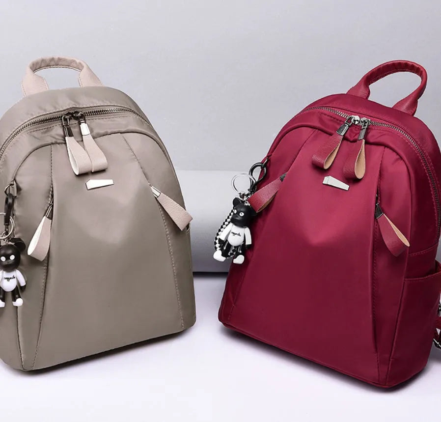 Medium square-shaped Oxford cloth rucksack in grey with double straps and a soft handle.