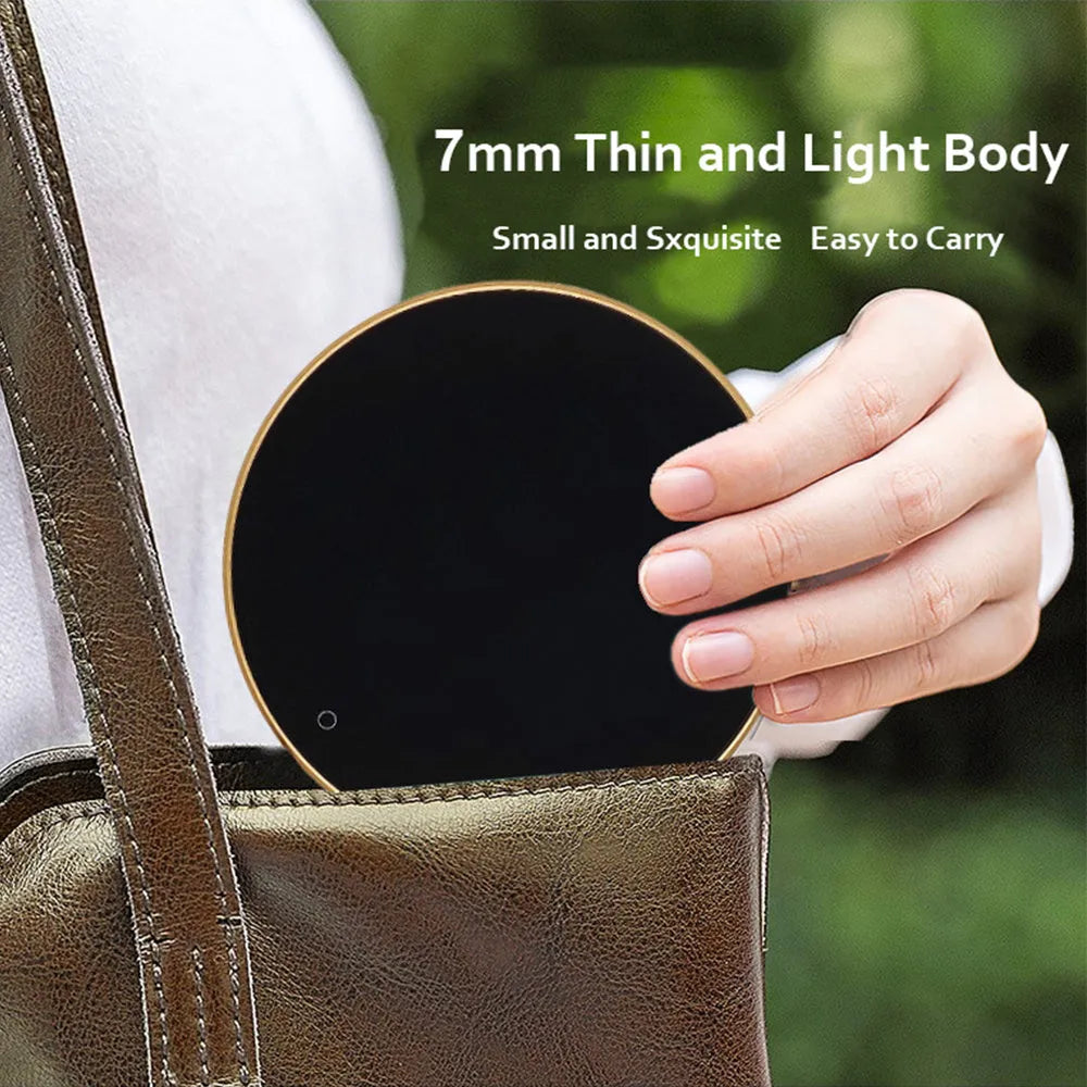 Black USB heating coaster pad for cups with LED indicator light on a wooden desk.