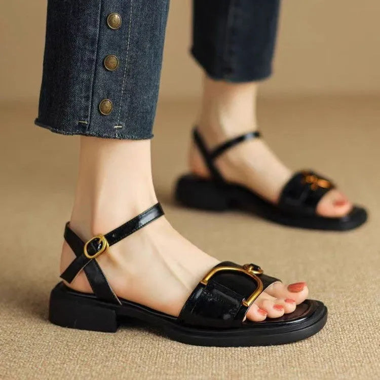 Women's black round-toe sandals with thick rubber sole and button fastening.