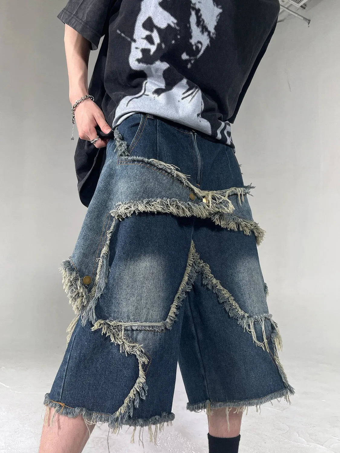 Blue retro-style men's denim shorts with a frayed five-pointed star design and a loose fit.