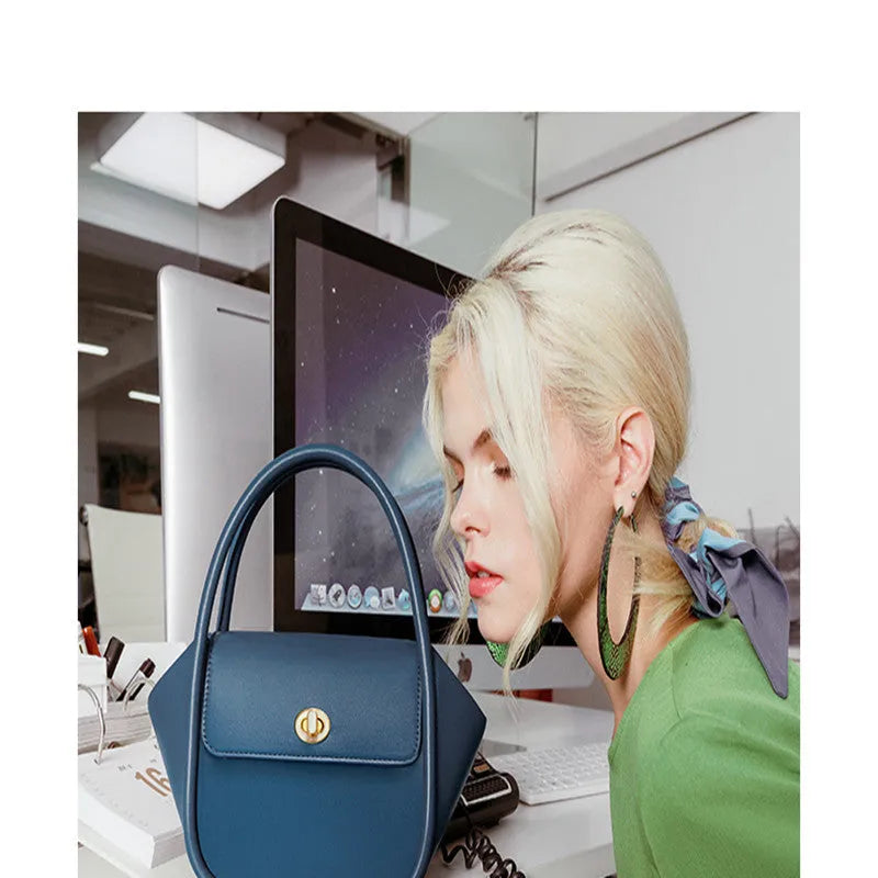 Women's leather wing tote bag in cow leather with a cross-body strap and buckle detail.