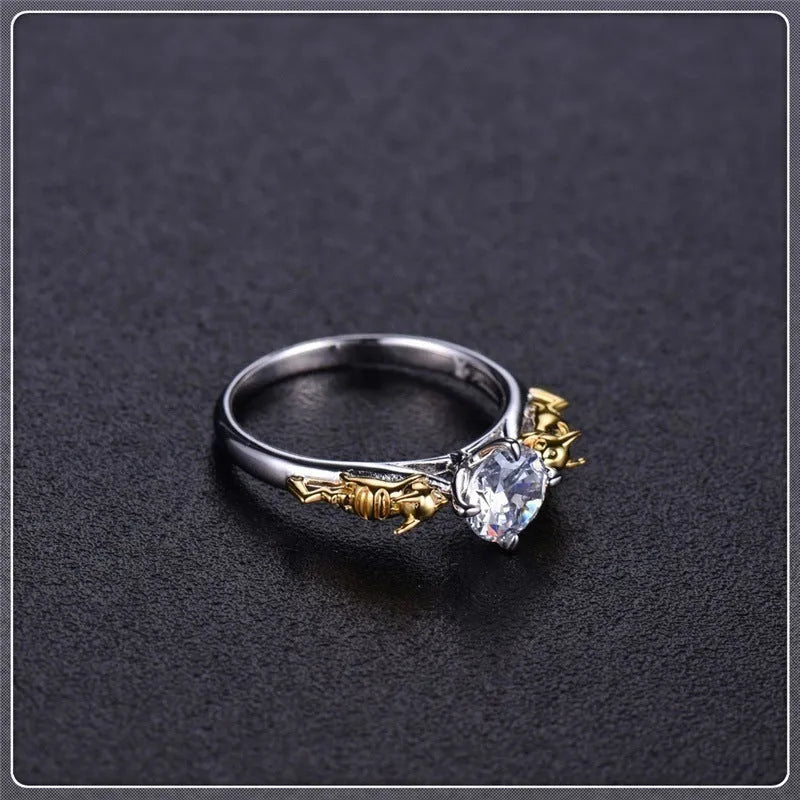 Copper crown-shaped crystal ring in a black gold tone on a neutral background.