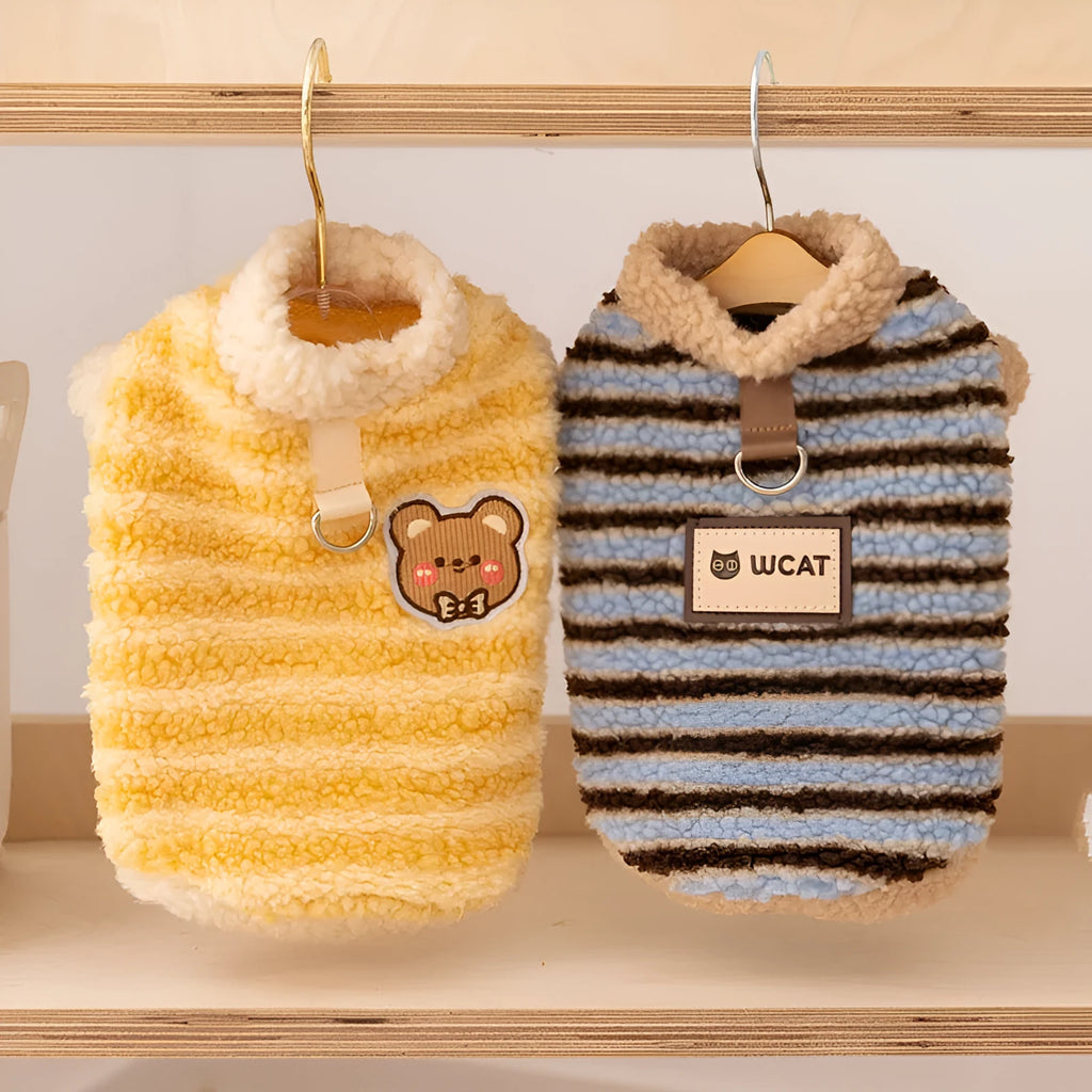 Blue striped lambskin fleece dog coat with drawstring and leash ring on a small dog against a neutral background