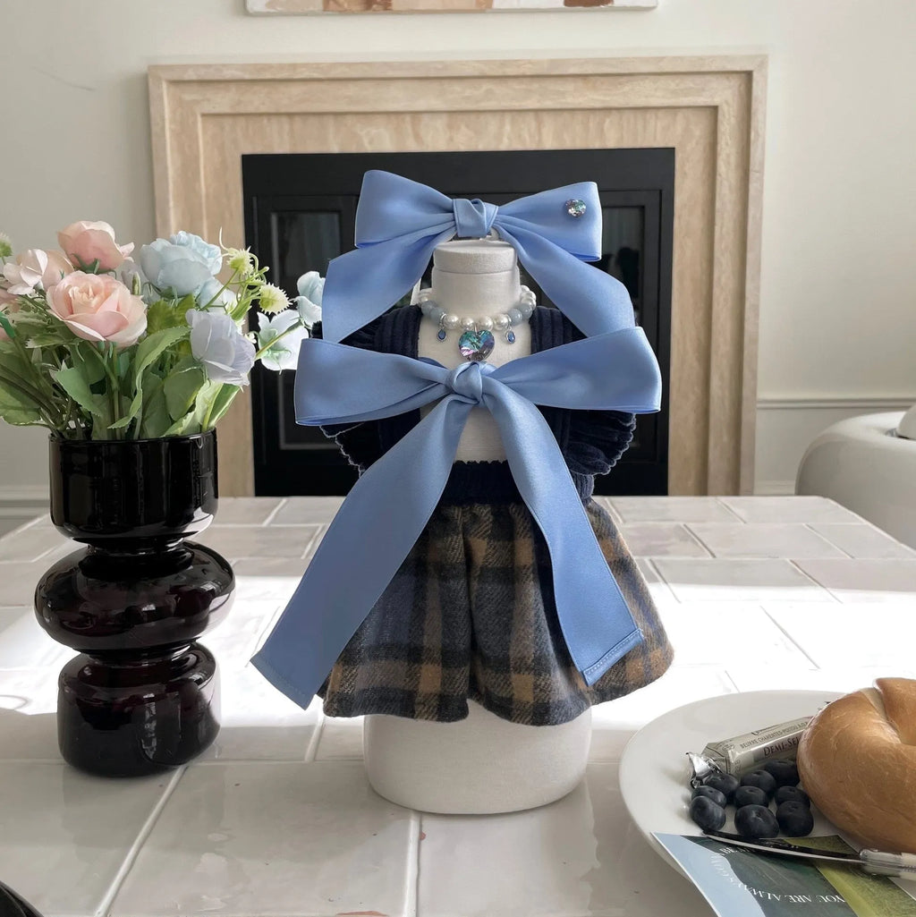 Adjustable blue dog hair band with a large pink princess bow on a white background