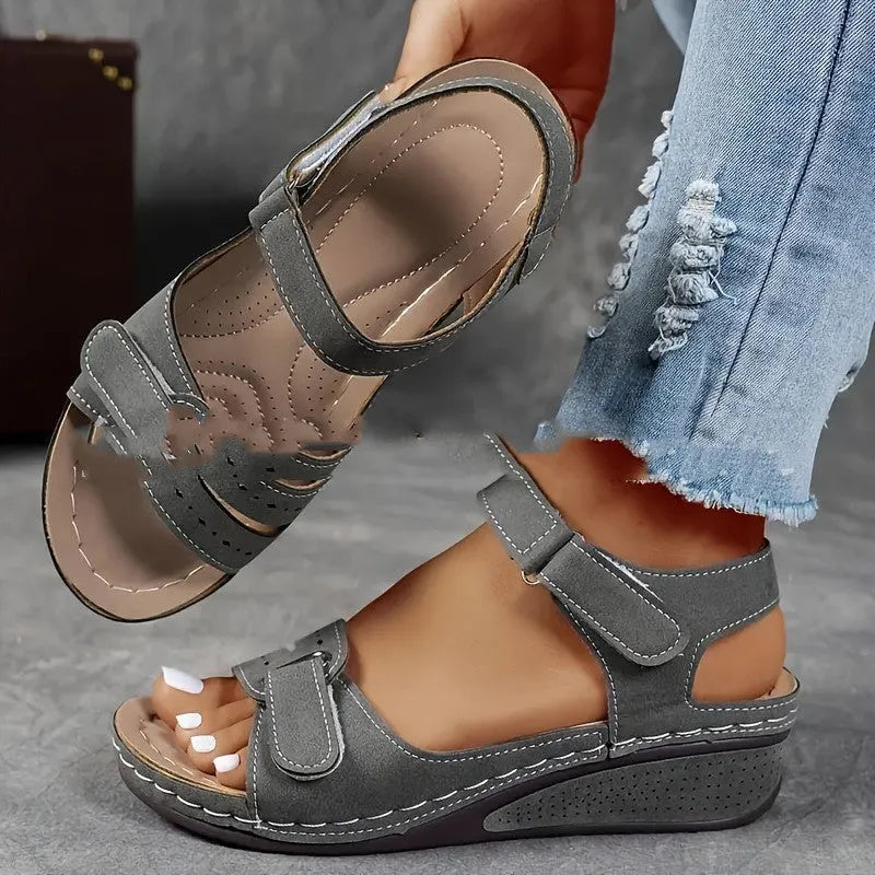 Women's beige strap sandals with a Velcro fastener and thick composite sole, shown in a round toe design.