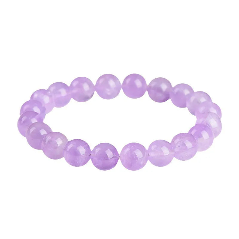 Lavender coloured amethyst crystal bracelet with round beads and a geometric water ripple design on a wrist.
