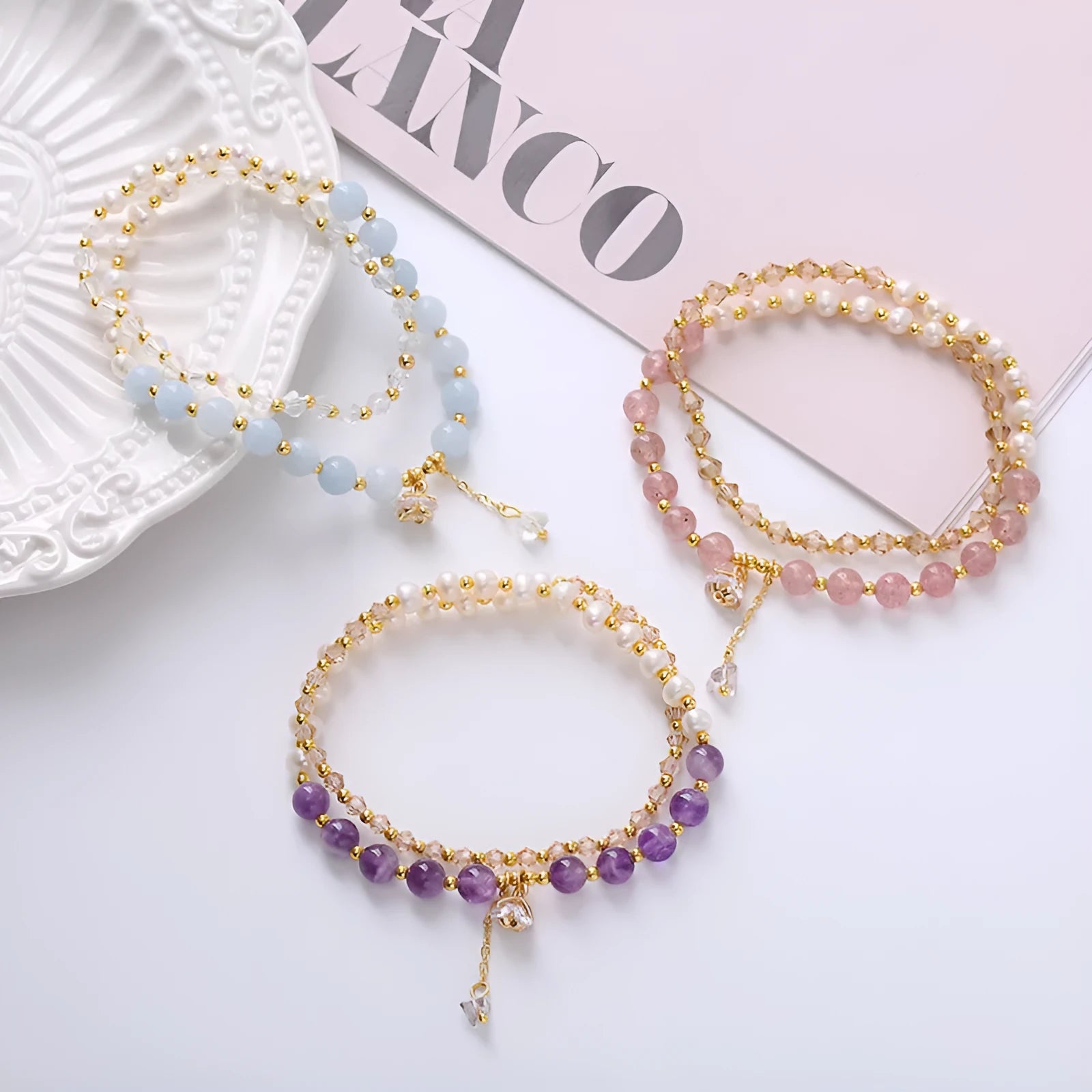 Close-up of a women's double ring bracelet with a freshwater pearl and amethyst crystal beads on a wrist.