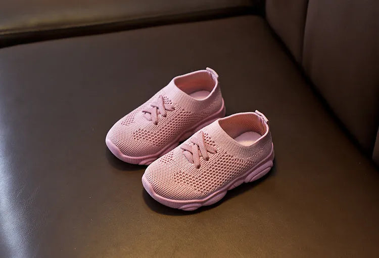 Children's fabric lazy shoe with a non-slip rubber sole, shown in colour options of white, black, pink, and grey.
