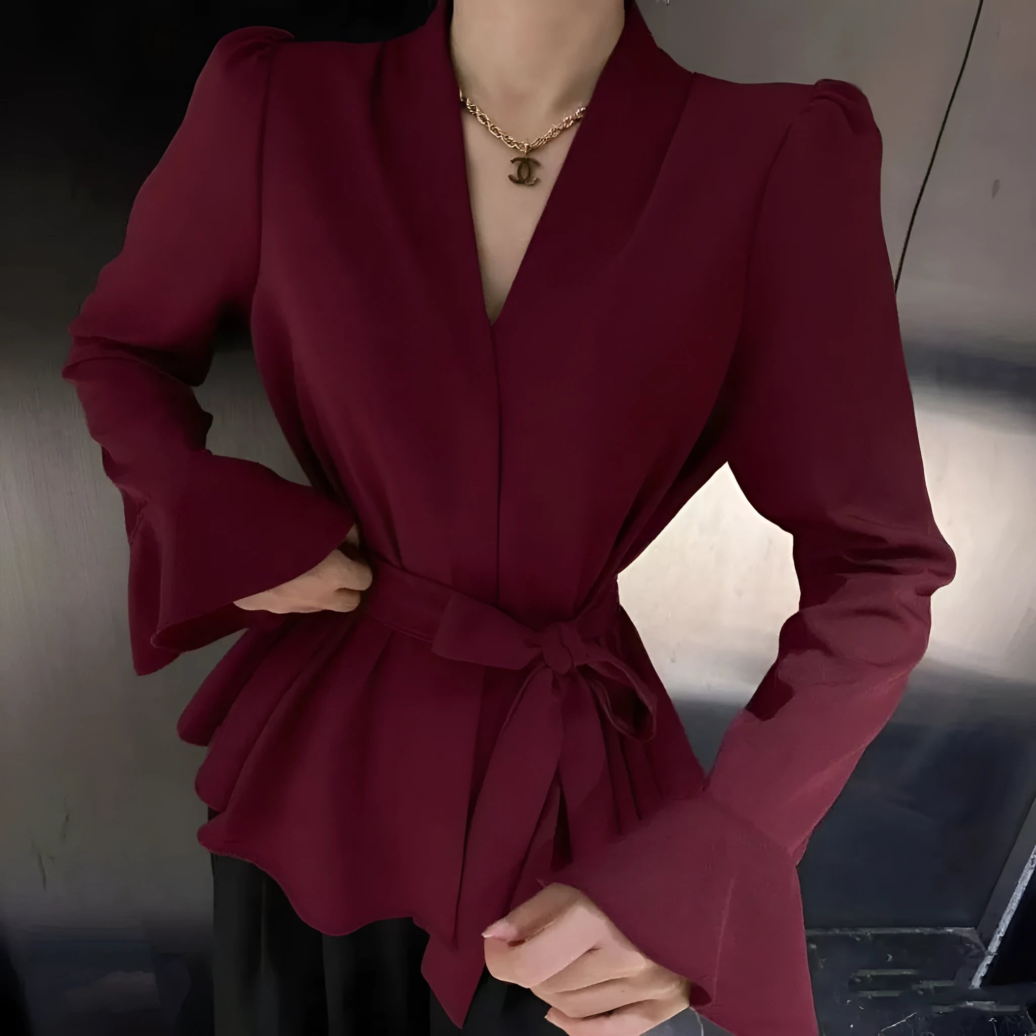 Women's black French-style shirt with irregular collar, long bell sleeves, and a tied front.
