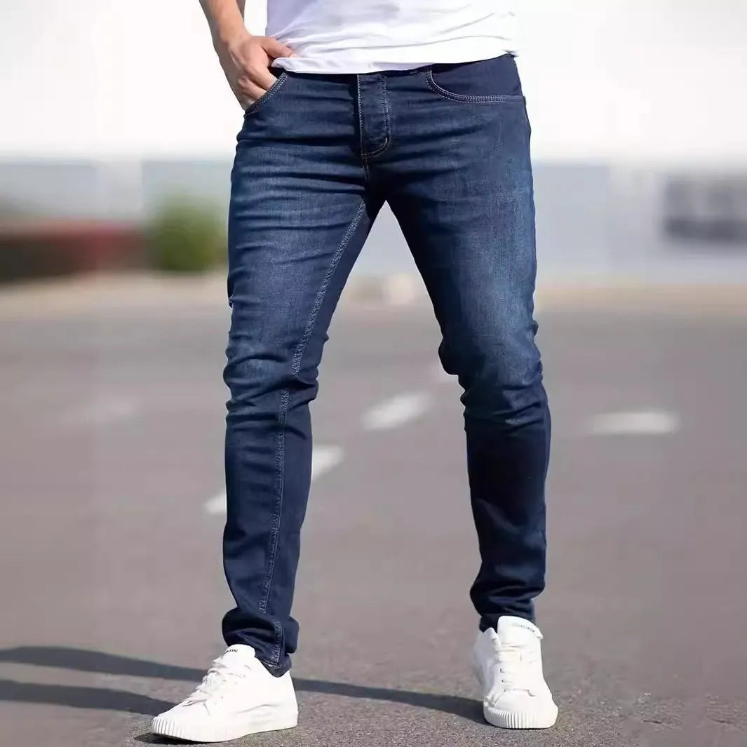 Man wearing dark blue slim-fit skinny jeans with a mid waist and zip fly.