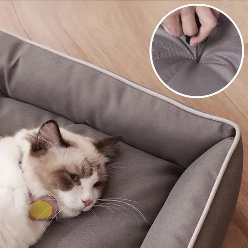 Grey waterproof dog sofa bed with padded sides on a wooden floor