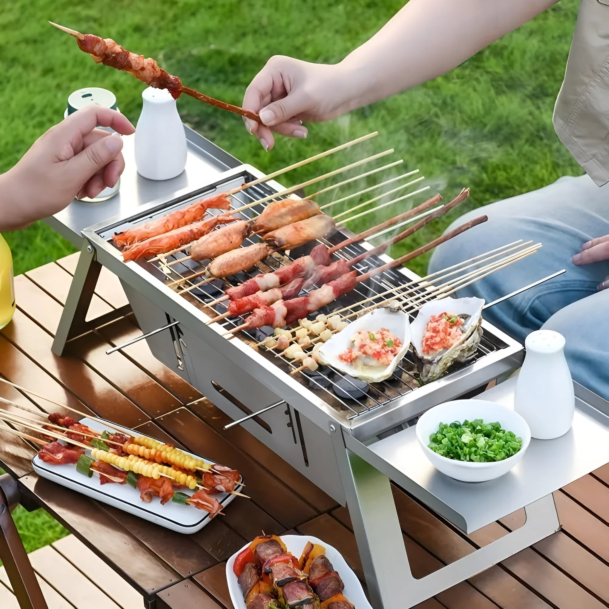 Small foldable metal charcoal grill with a carrying handle, shown in a compact stored position.