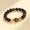 Handmade black agate bracelet with zodiac animal charms and gold tiger eye beads on wrist