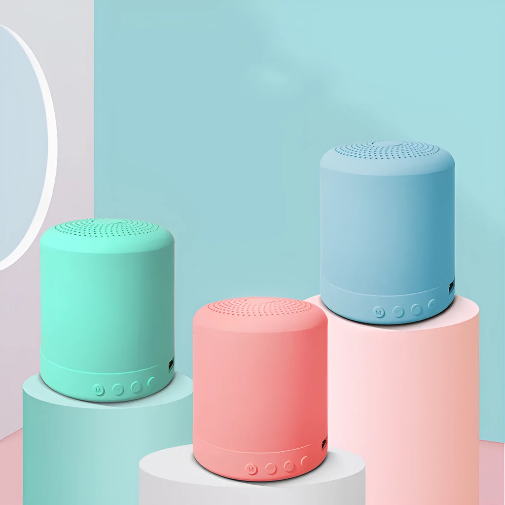 Small A11 wireless stereo speaker in black, pink, blue, or green colours on a surface.