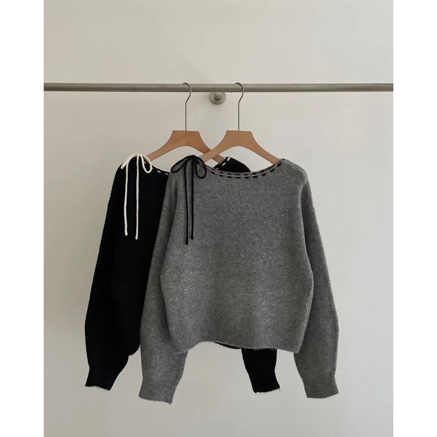 Grey loose-fitting women's knitwear pullover on a hanger.