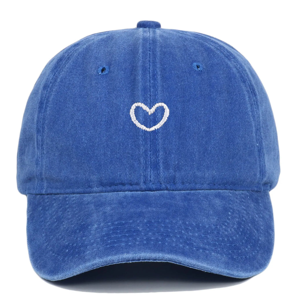 Adjustable cotton baseball cap featuring a distressed embroidered love heart on the front, shown in a selection of colours.