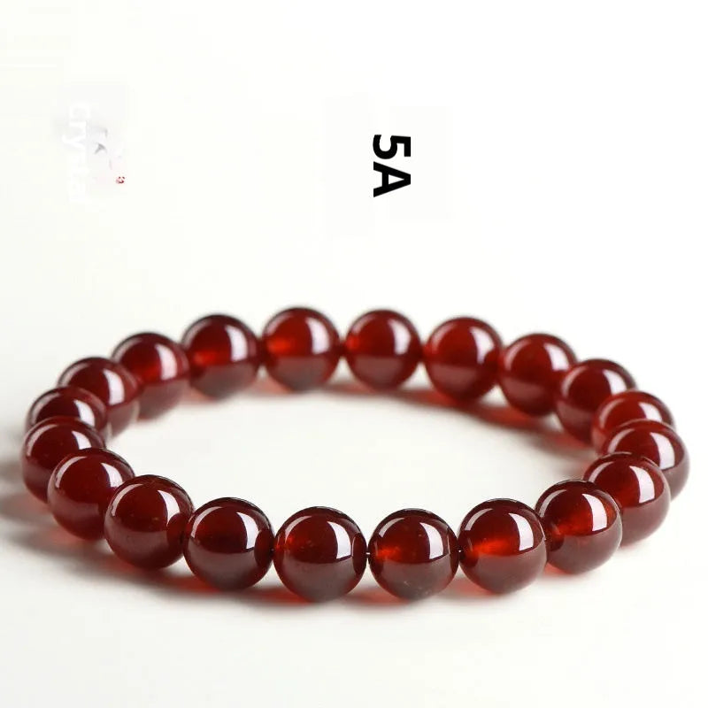 Orange red garnet crystal ball bracelet with retro ruyi design on a wrist