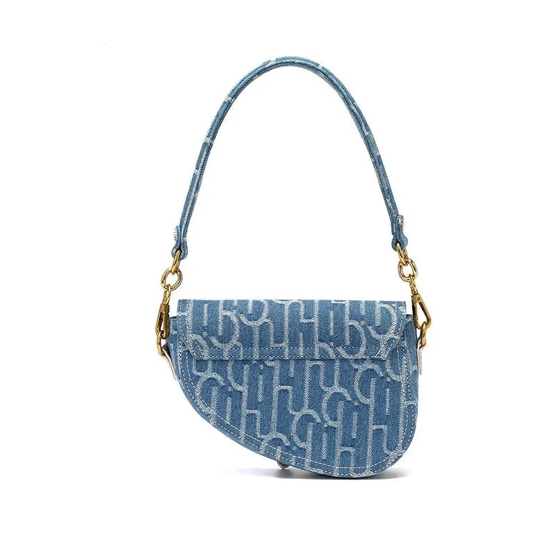 Women's vintage denim saddle bag in blue with cross-body strap and zip pocket interior