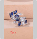 Copper leaf-shaped ring with horse eye design and zircon stones on a finger, showing adjustable opening.