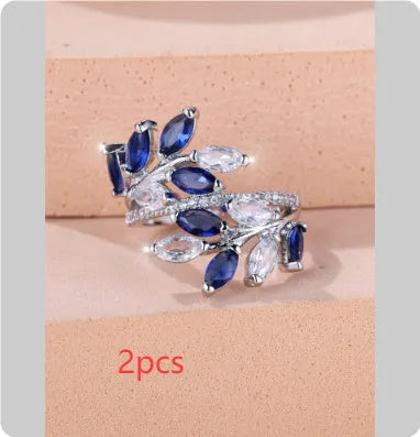 Copper leaf-shaped ring with horse eye design and zircon stones on a finger, showing adjustable opening.