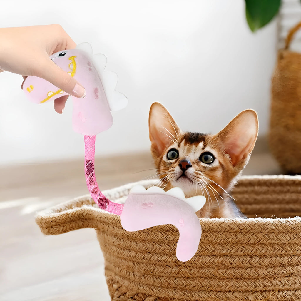Set of cat toys including plush animals, rope toys, and springs on a pink background