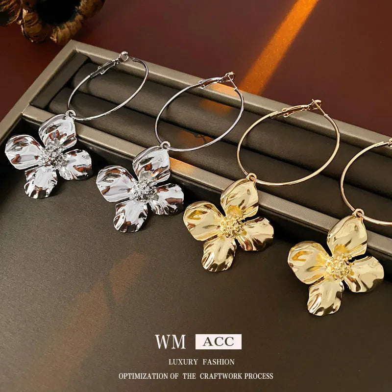 Geometric metal flower earrings with silver needle detail in gold or silver electroplated finish.