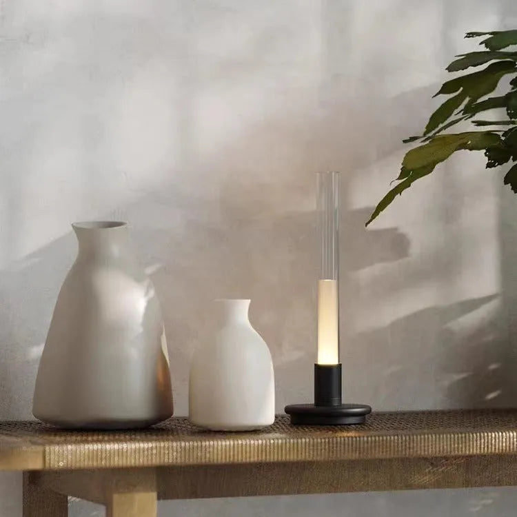 Black Nordic style candlelight table lamp showing three-colour LED light settings on a wooden desk.