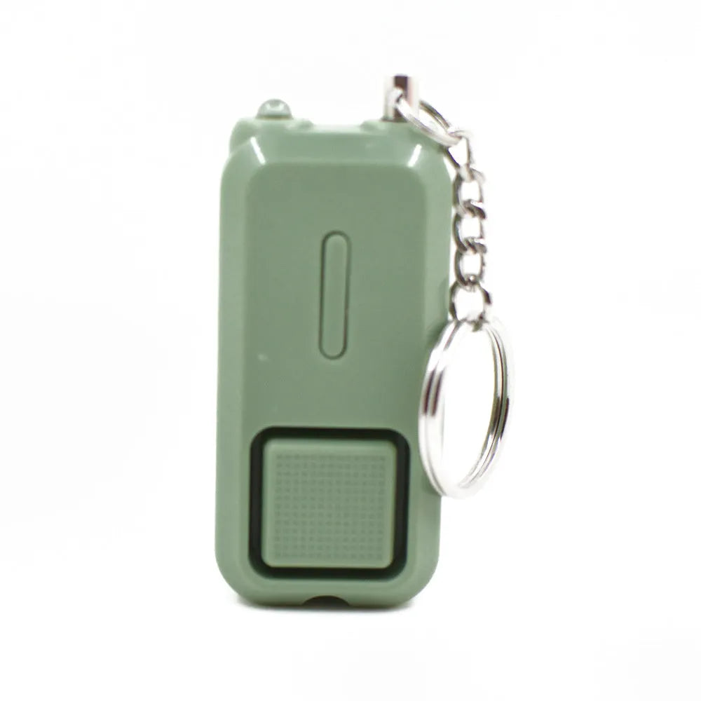 Small pink personal safety alarm on a keyring with a pull-pin activation mechanism.