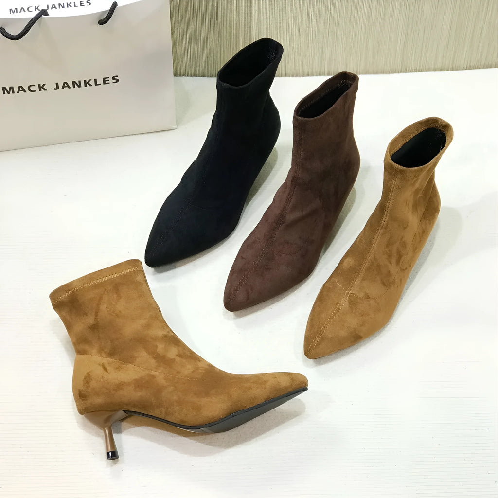 Black pointed toe women's ankle boots with a stiletto heel and mid-calf sock length on a white background