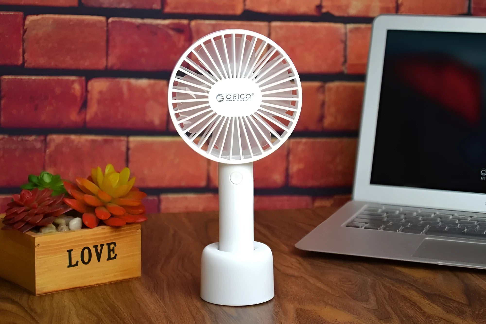 White ORICO FH1 portable USB rechargeable small fan on a desktop.