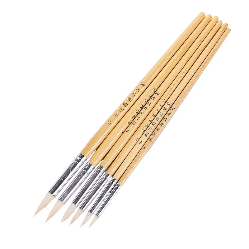 Set of six wooden-handled artist pen brushes with pointed tips on a white background.