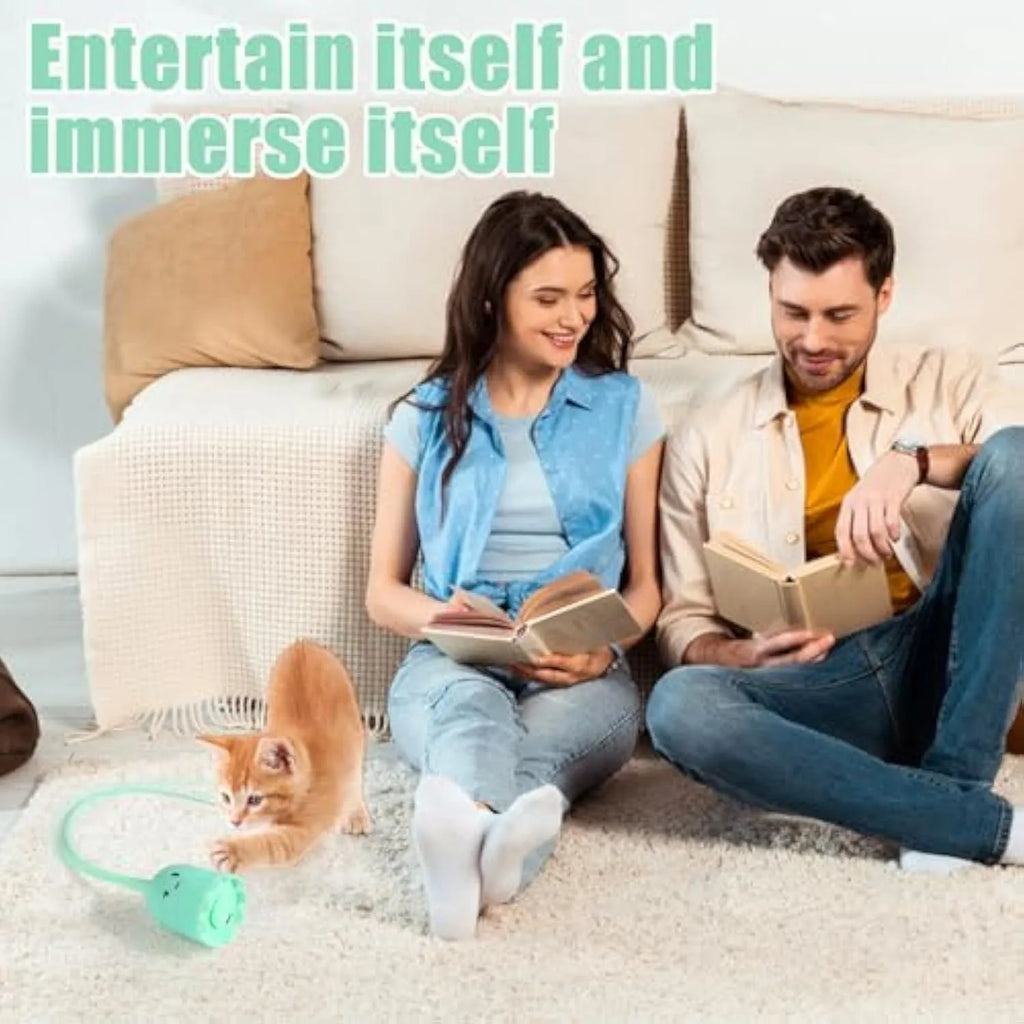 Green rechargeable automatic electronic cat wand toy with swinging silicone tail on a wooden floor