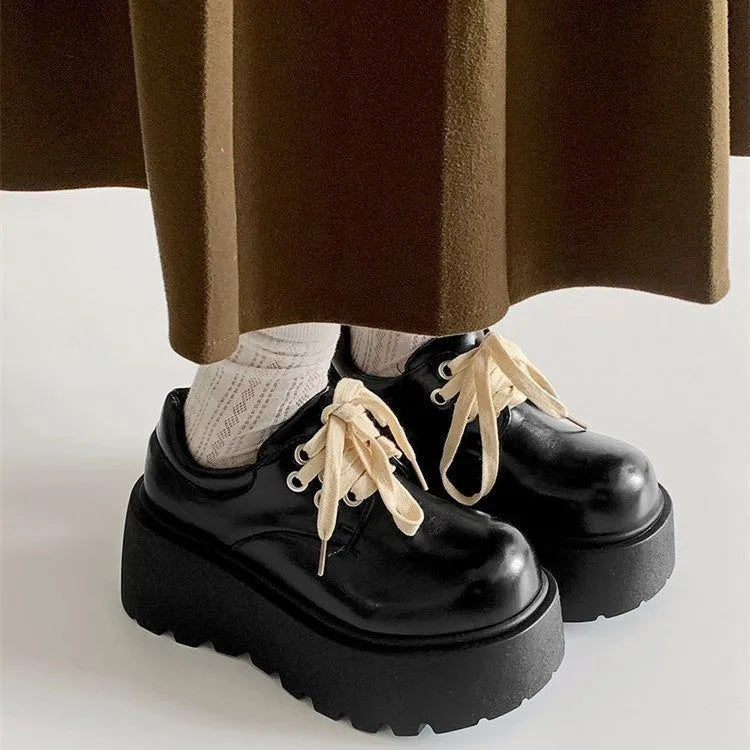 Matte black women's lace-up leather shoes with a thick sole and a chunky heel.