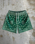 Man wearing loose-fitting digital print beach shorts in a contemporary colour, showing the elastic waistband and quick-dry milk silk fabric.