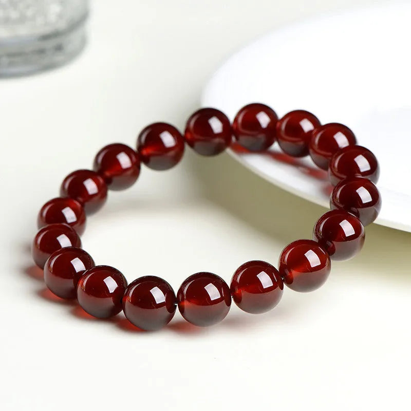 Orange red garnet crystal ball bracelet with retro ruyi design on a wrist