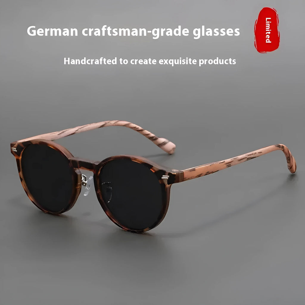 Retro round frosted sunglasses in leopard print and sand colours on a patterned background.