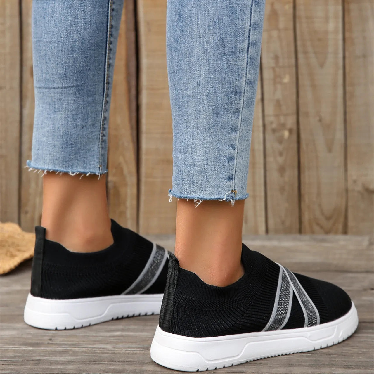 Black women's flat shoes with flyknit mesh upper, round toe, tassel detail, and flat rubber sole.