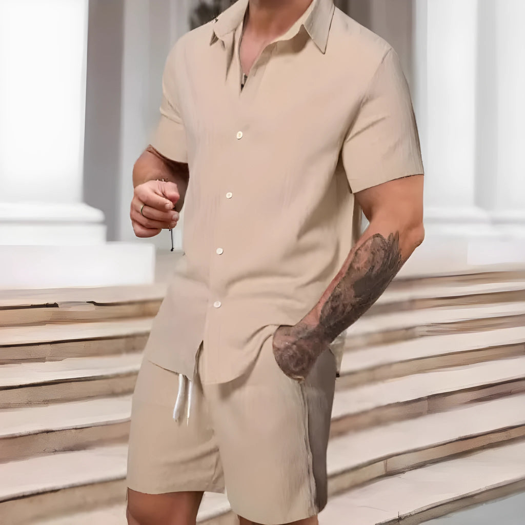 A man wearing a striped short-sleeve shirt and matching shorts from a casual suit set.